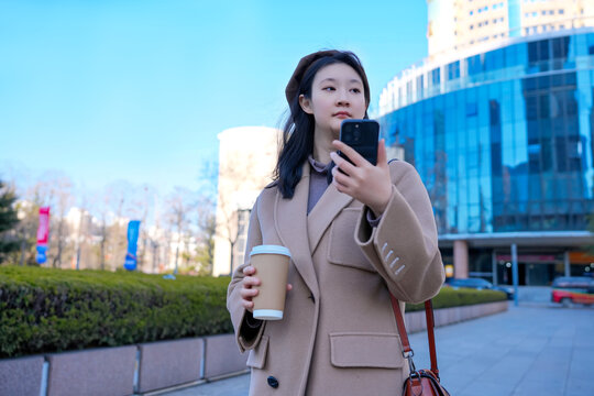 办公楼外自信女性茶歇