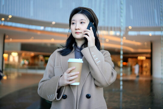 商场走廊打电话的年轻女子