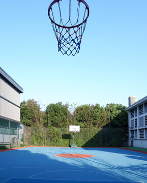 空旷的篮球场和蓝天下的建筑物
