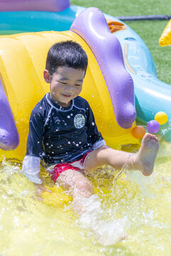一个小男孩在水上乐园玩滑梯