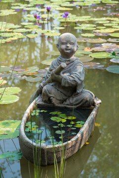 睡莲池塘里划船的小和尚雕像