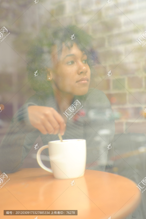女子坐在冒着烟雾的咖啡前