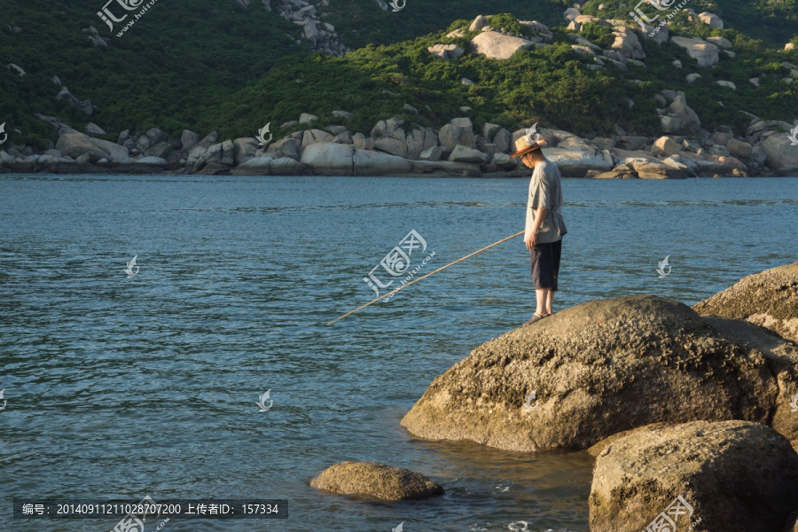 海边岩石上的垂钓者