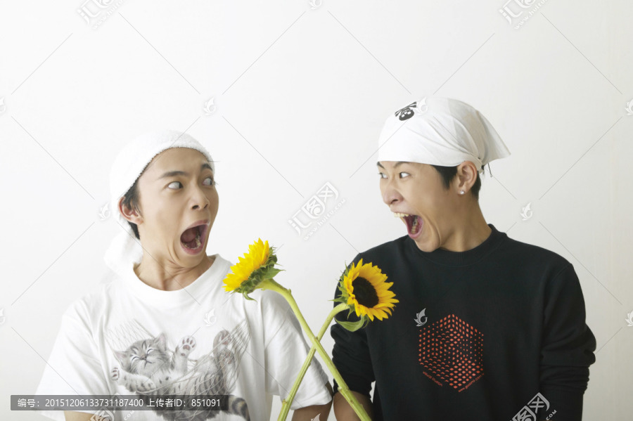 两个年轻人拿着向日葵