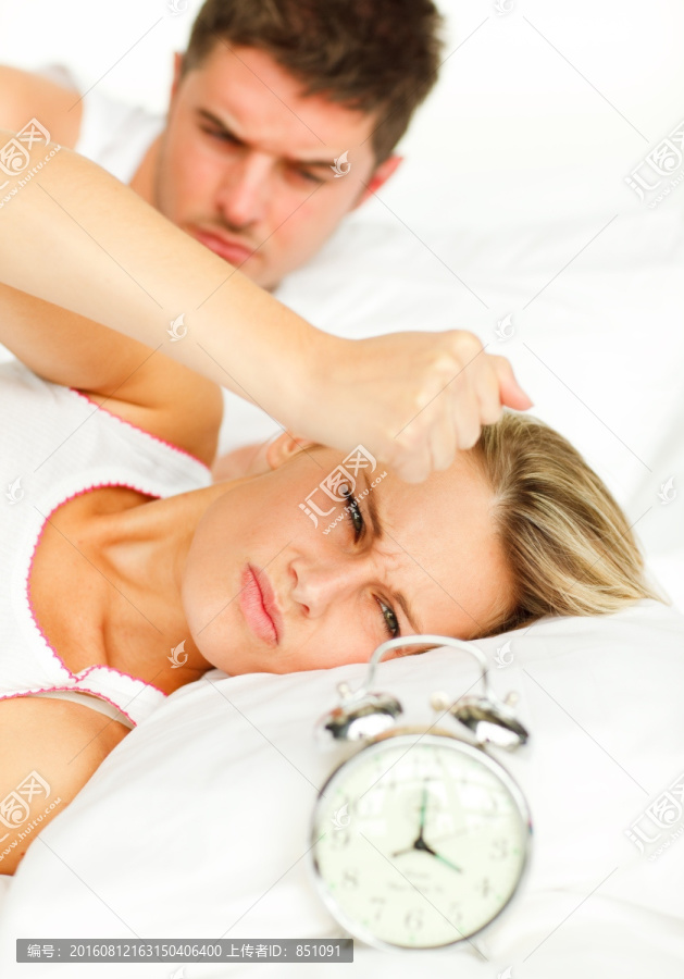 厌恶闹钟躺在床上的夫妇
