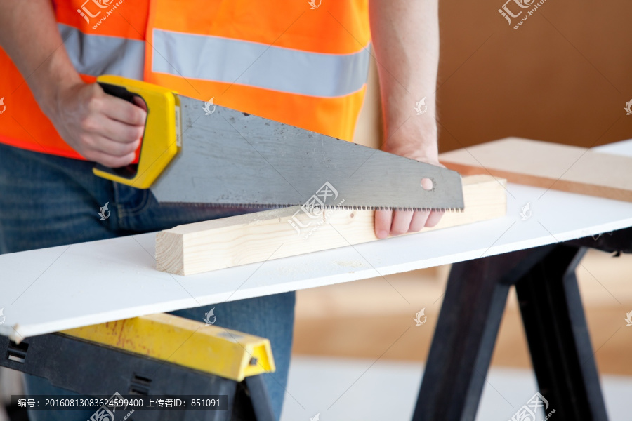 工人在工作时锯木板的特写