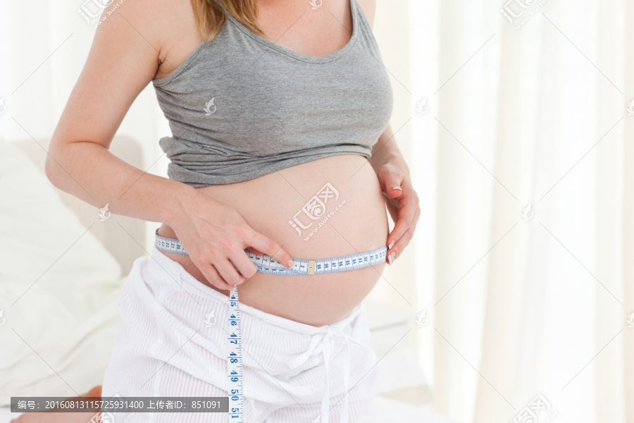 在家测量腰围的孕妇