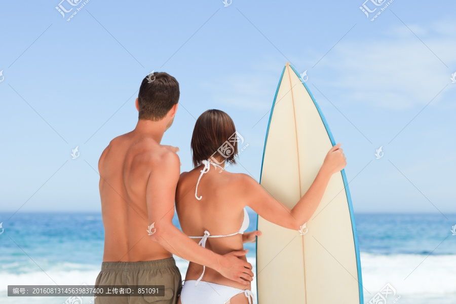 手拿冲浪板的情侣背影