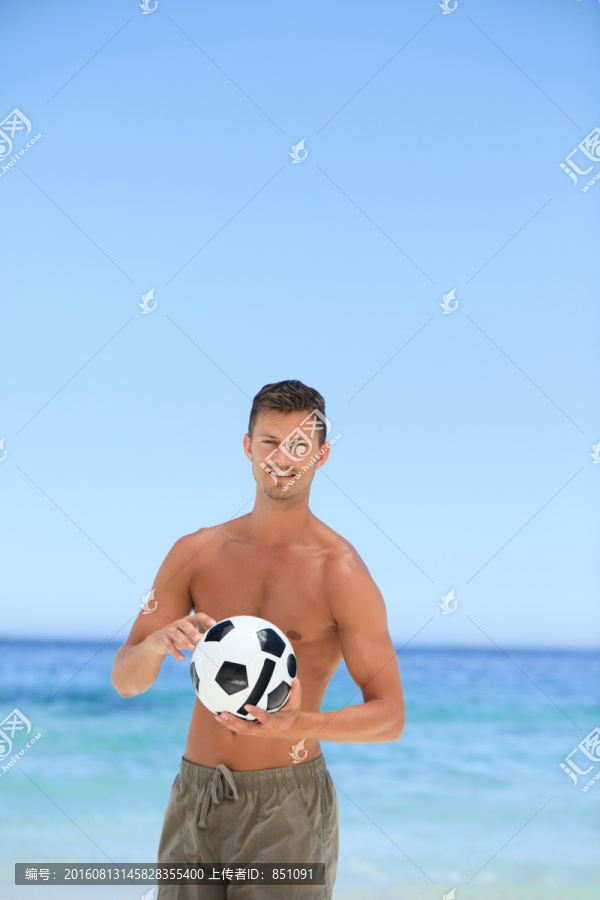 沙滩上玩足球的男人
