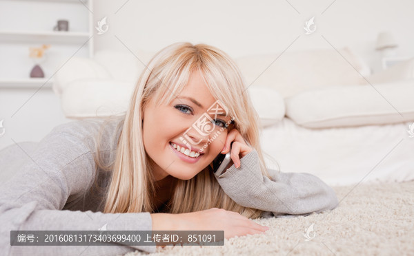 躺在地毯上打电话的女人