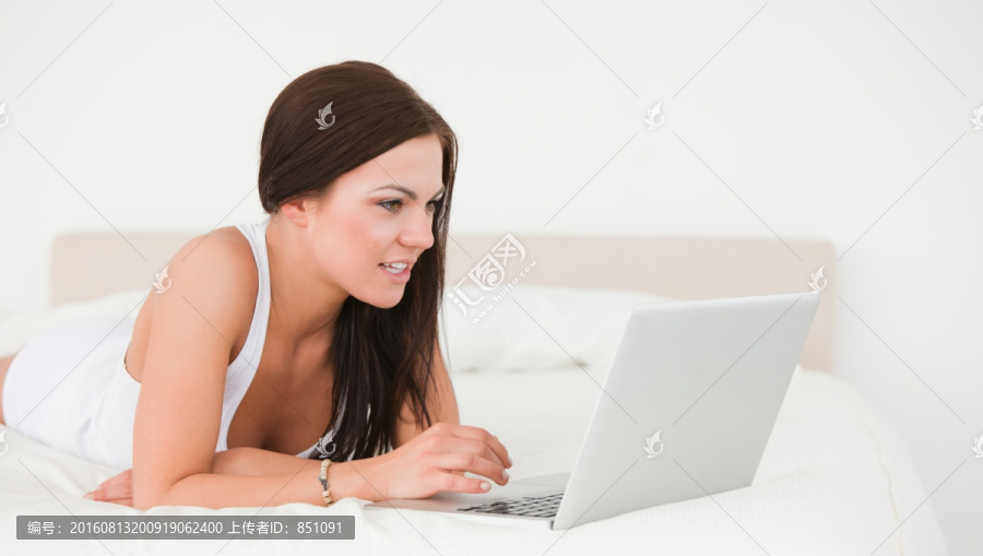 在床上使用电脑的女人
