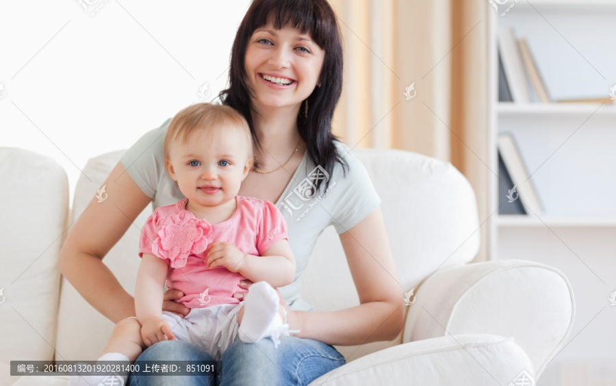 妈妈抱着宝宝坐在沙发上
