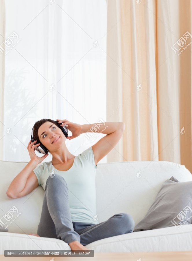 坐在沙发上听音乐的女人