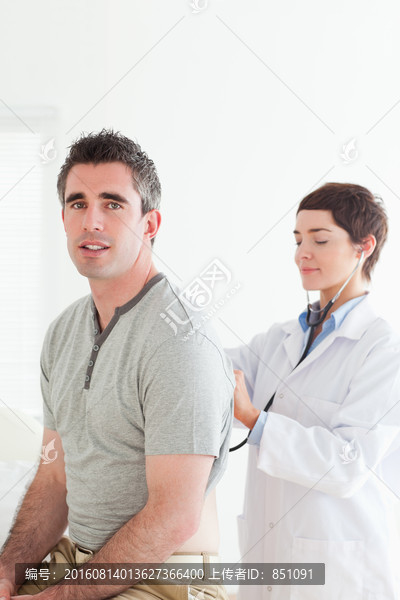 用听诊器检查背部情况的女医生