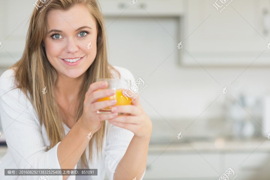 女人手拿橙汁