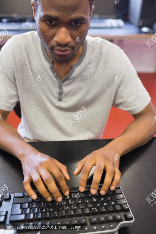 坐在机房电脑前的男学生
