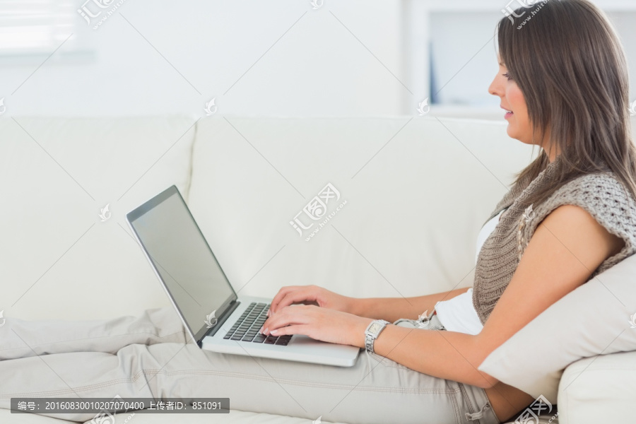 坐在沙发上玩电脑的女人