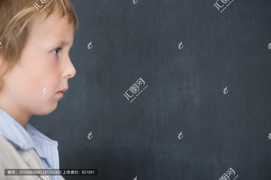 打扮成老师在黑板上写字的小男孩