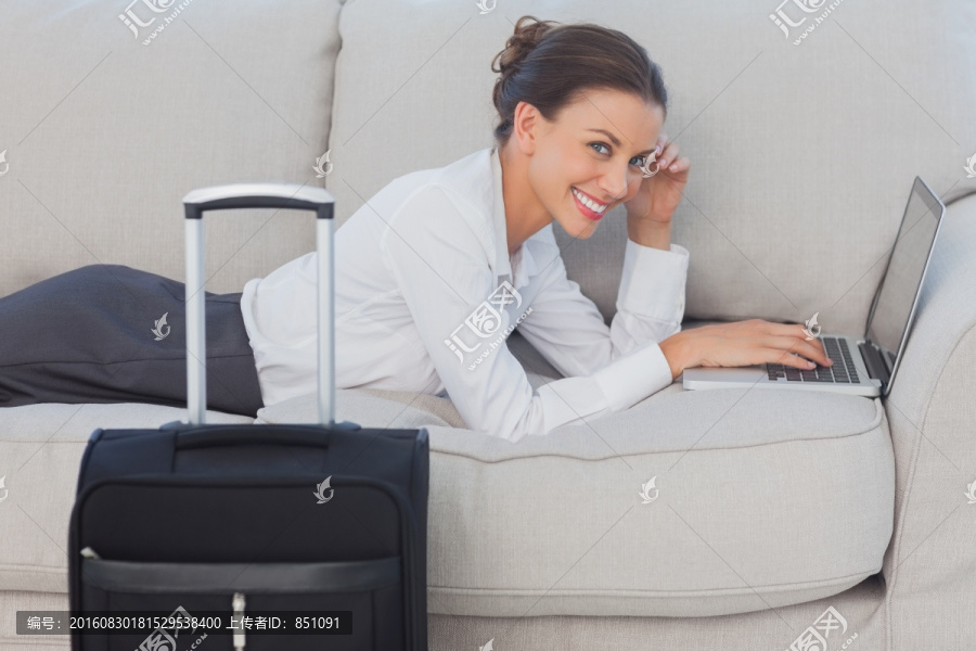 商业女人躺在沙发上看着相机