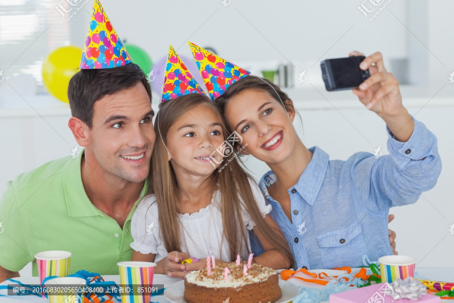 一家人微笑着看着手机拍照