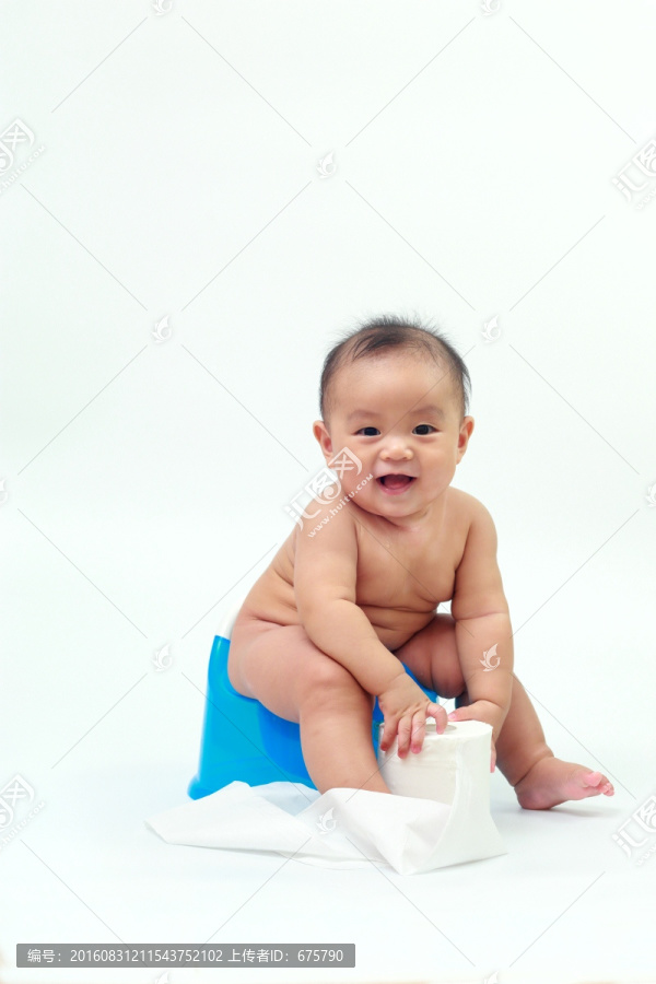 胖胖婴儿坐在坐便器上抓卷纸玩