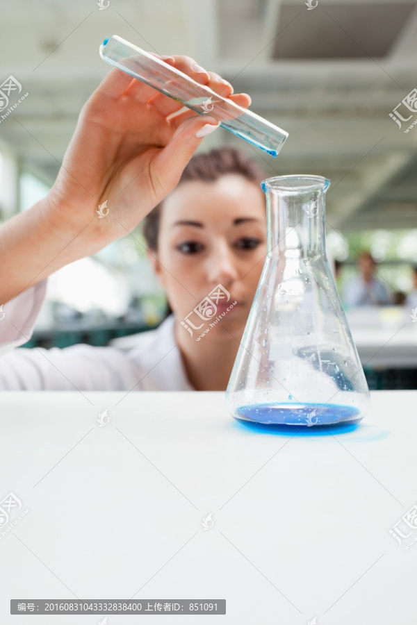 在倒藍色液體的女科學家