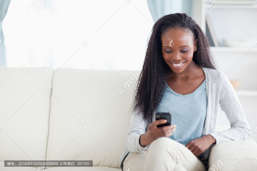 微笑的女人用手机发短信
