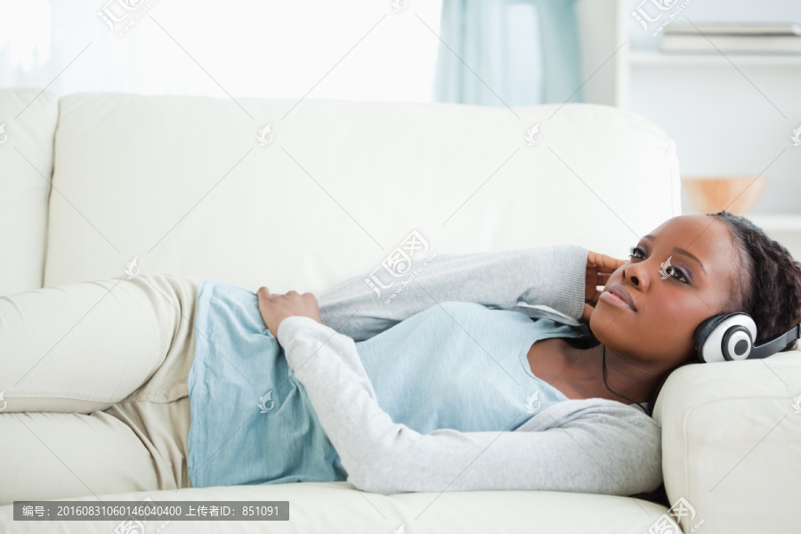 女人躺在沙发上听音乐