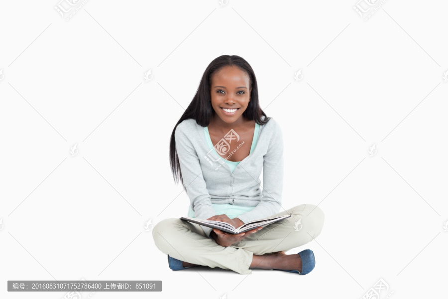 微笑的女人坐在地上看书