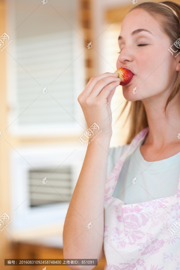 一个年轻的女人在吃草莓