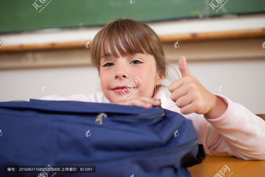 坐在教室里竖起大拇指的女孩