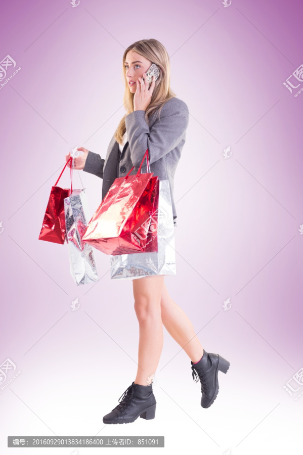 时尚的金发女郎拿着购物袋