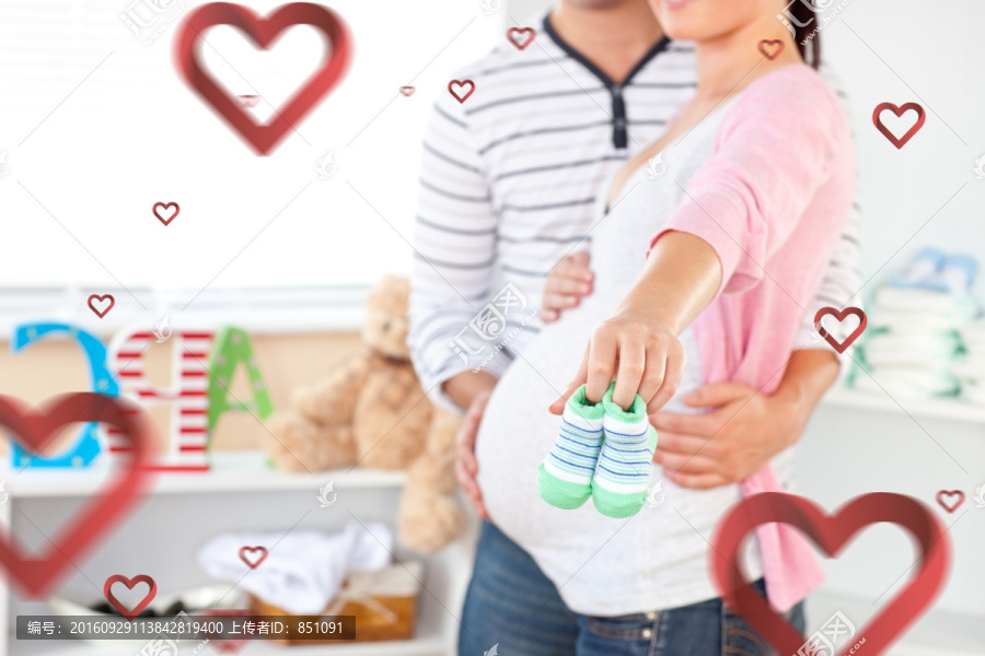 接近一個光明的孕婦抱著嬰兒鞋