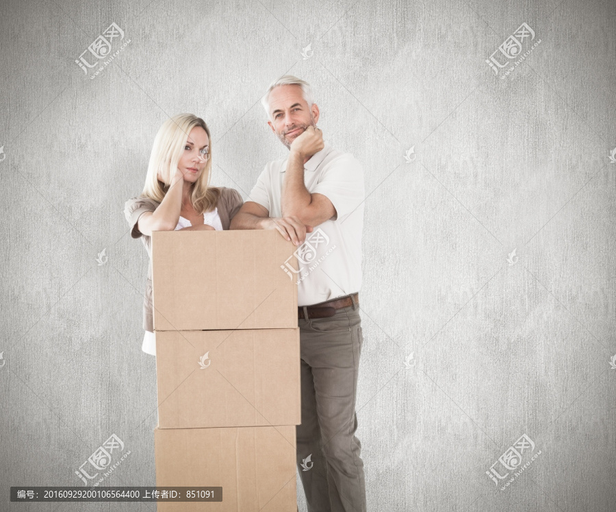 夫妇靠着纸箱看着镜头的复合形象