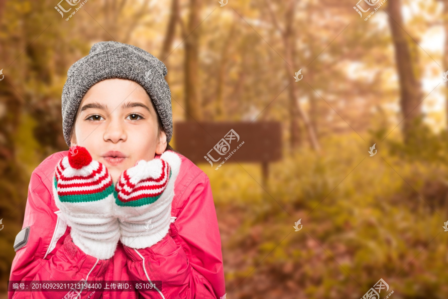 裹著厚衣服小女孩在森林里吹氣