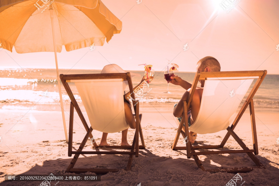 夫妇坐在沙滩椅上碰杯