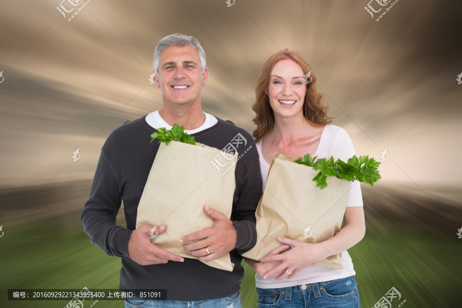 夫婦微笑著抱著購物袋的復合形象