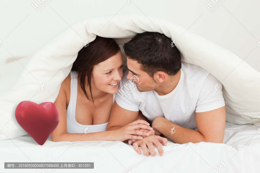 趴在床上微笑著的夫婦