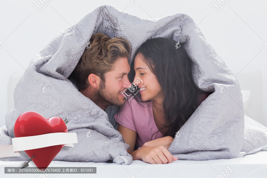 趴在床上微笑著的夫婦