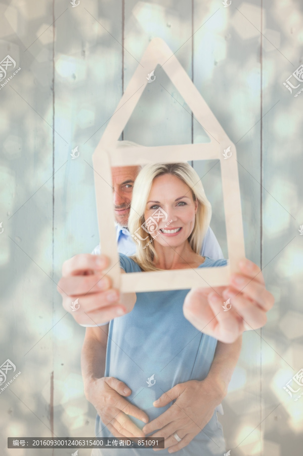 微笑著看著房屋模型的夫婦