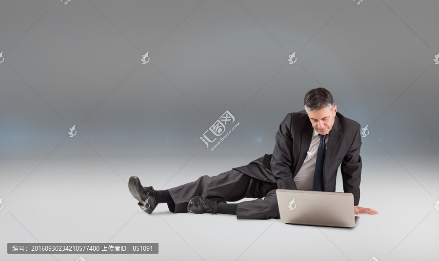 坐著使用筆記本電腦的男人