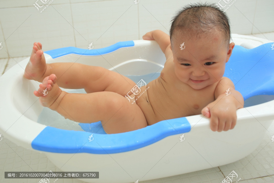 胖胖的婴儿在洗澡盆里想坐起来