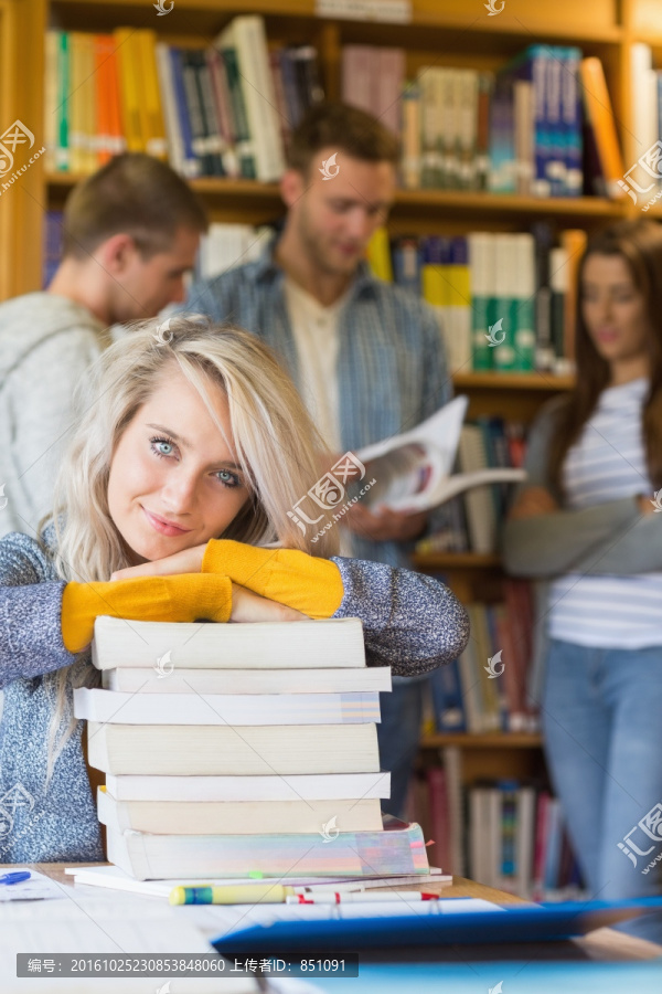 在图书馆里趴在一堆书上的女学生