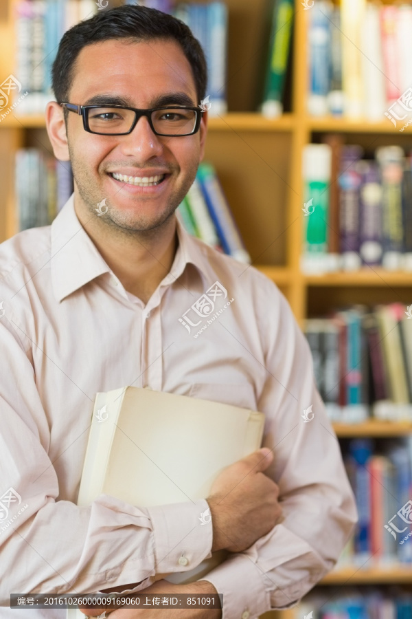 抱着书在图书馆里的男大学生