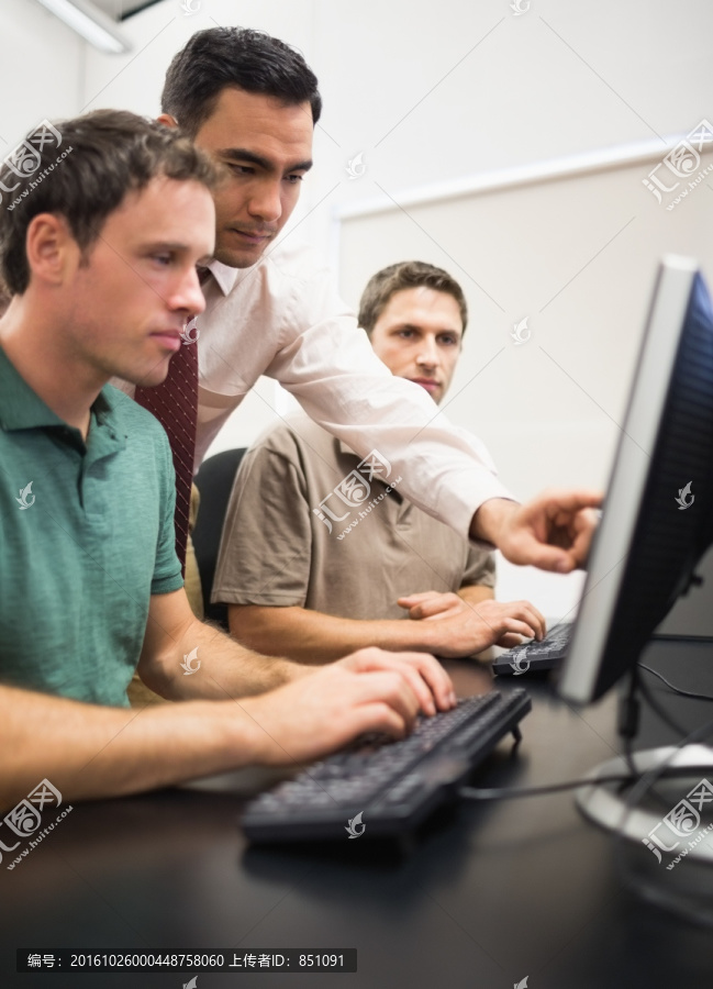 男计算机老师在教学生使用电脑