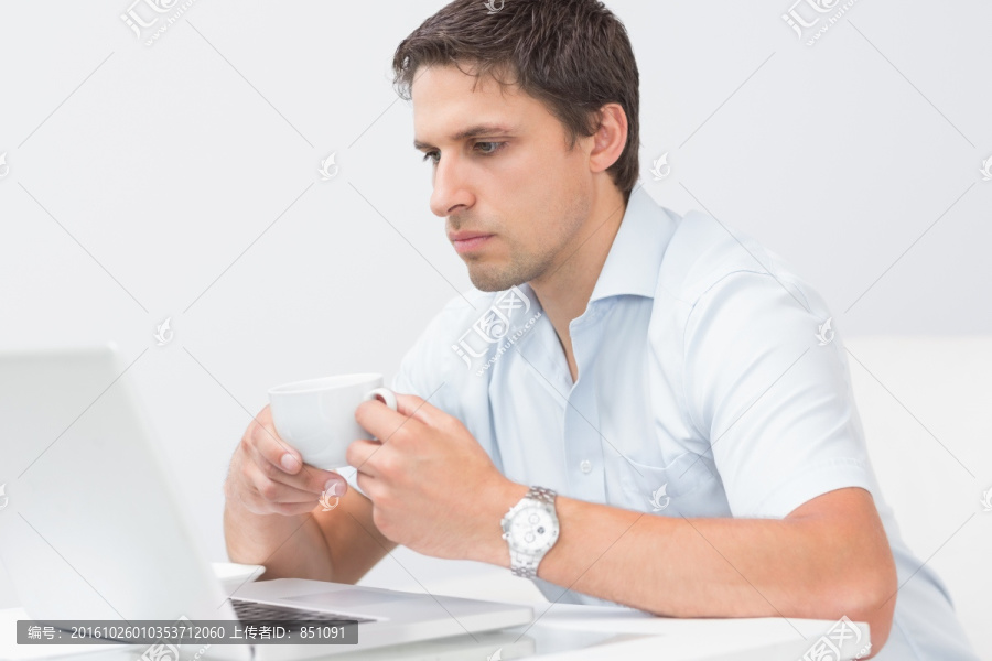 坐在沙发上使用笔记本电脑的男人