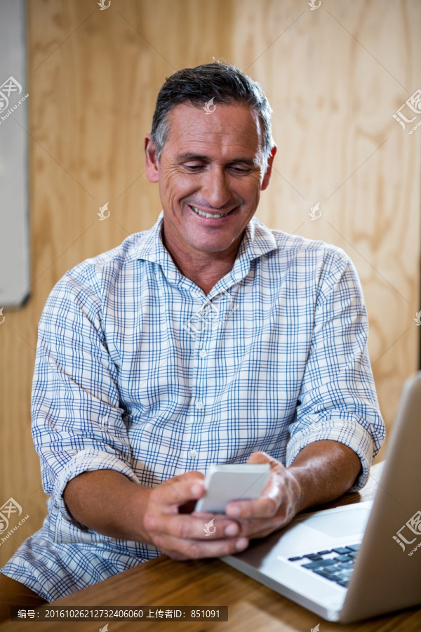 微笑着使用手机的商务男人
