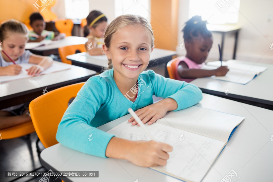 微笑的学生坐在书桌上