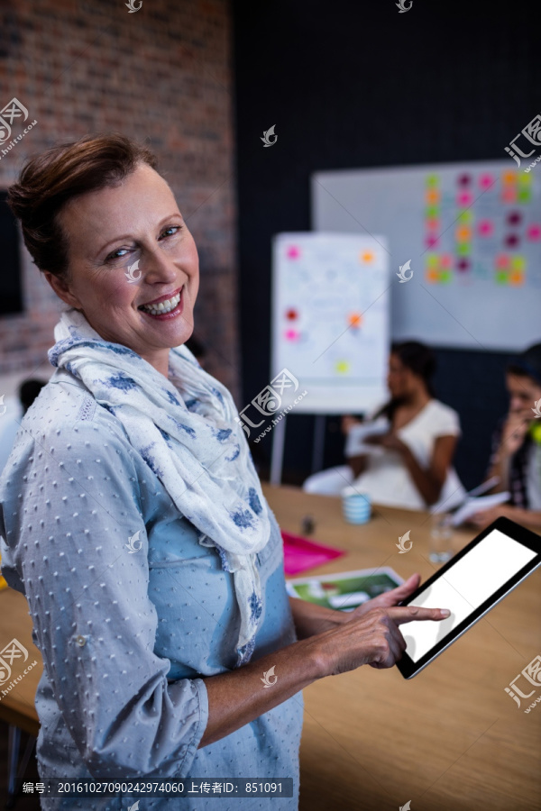 微笑着使用平板电脑的女人