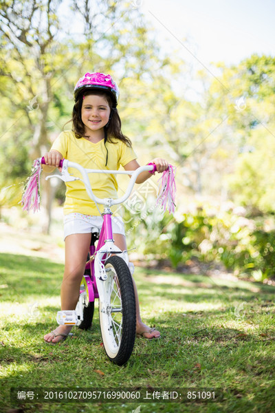 微笑的女孩在公园里骑自行车